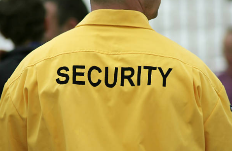 Man wearing yellow security top.